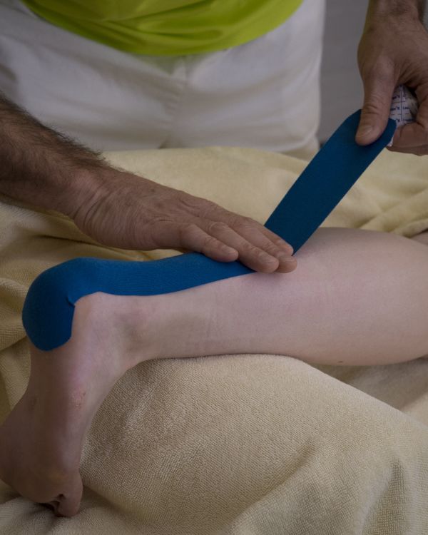 Tape wird am Bein angelegt